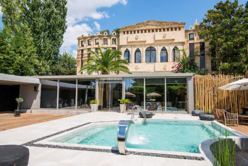 a swimming pool in front of a house at Mikelina Boutique Hotel in Pallíni