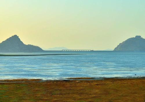 a large body of water with mountains in the background at Thour Nature Resort - Jawai Leopard Safari Camp in Bera