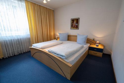 małe łóżko w pokoju z oknem w obiekcie Appartement Pavillon w mieście Fulpmes