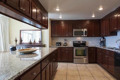 a kitchen with wooden cabinets and a granite counter top at Seahaven Beach Hotel Panama City Beach in Panama City Beach