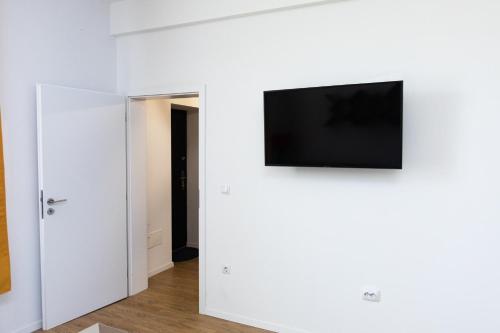 sala de estar con TV en una pared blanca en Colorful & Cozy Condo, en Cluj-Napoca