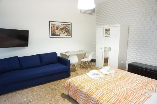 a living room with a blue couch and a bed at Bed a Cavour in Gaeta