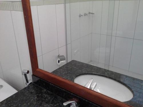 y baño con lavabo y ducha con espejo. en Casa Poletto, en Morretes