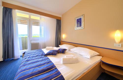 a hotel room with two beds and a television at Hotel Dražica - Hotel Resort Dražica in Krk