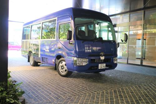 un autobús azul estacionado frente a un edificio en Hotel Trad Hakata en Fukuoka