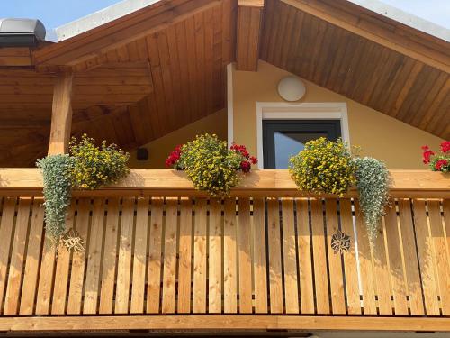 una terraza de madera con macetas. en BeeWood apartment, en Križe