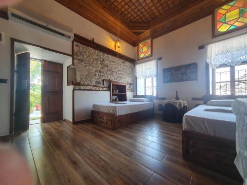 duży pokój z dwoma łóżkami i kominkiem w obiekcie RIVA Guest House w Gjirokastrze