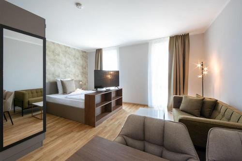 a hotel room with a bed and a couch at Brera Serviced Apartments Ulm in Ulm