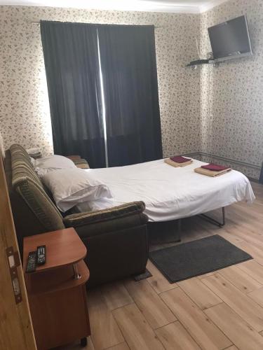 ein Bett und ein Sofa in einem Zimmer in der Unterkunft The Garden in Myrhorod