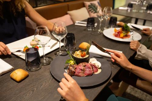 a group of people sitting at a table with a plate of food at Novotel Strasbourg Centre Halles in Strasbourg