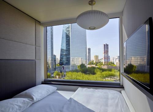 a bedroom with a large window with a view of a city at citizenM Paris La Défense in Nanterre