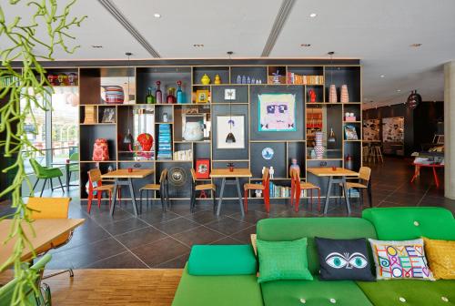 a living room with a couch and tables and chairs at citizenM Paris La Défense in Nanterre