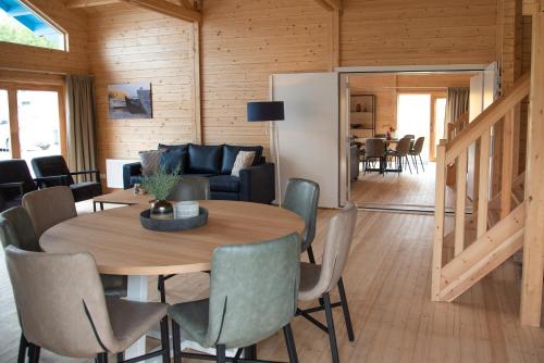 a dining room and living room with a table and chairs at Luxe Chalets in Zeeland aan de kust in Sint Annaland