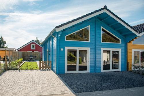 a blue house with a red house at Luxe Chalets in Zeeland aan de kust in Sint Annaland