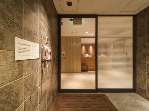 東京的住宿－橫丁品川青物超級酒店，一个带玻璃门的大堂和一间房间