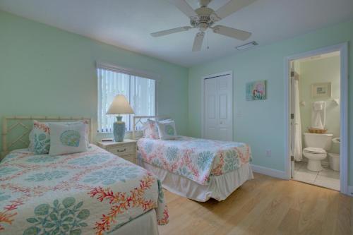 a bedroom with two beds and a ceiling fan at Anna Maria Island Beach Sands 101 in Bradenton Beach
