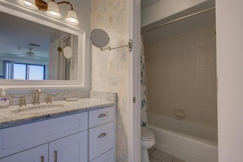 a bathroom with a sink and a toilet and a mirror at Anna Maria Island Beach Sands 101 in Bradenton Beach
