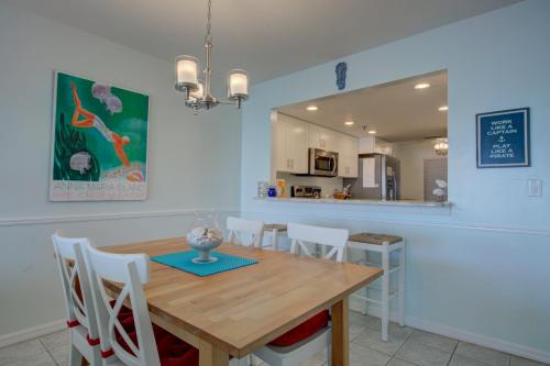 a kitchen and dining room with a wooden table and chairs at Anna Maria Island Beach Sands 101 in Bradenton Beach