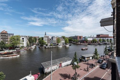 - une vue sur une rivière avec des bateaux dans une ville dans l'établissement Hotel Amstelzicht, à Amsterdam