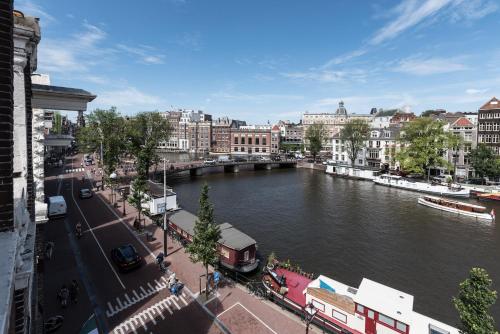 une rivière dans une ville avec un pont et des bâtiments dans l'établissement Hotel Amstelzicht, à Amsterdam