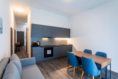 a kitchen and dining room with a table and blue chairs at SWAS by Livingdowntown in Zurich