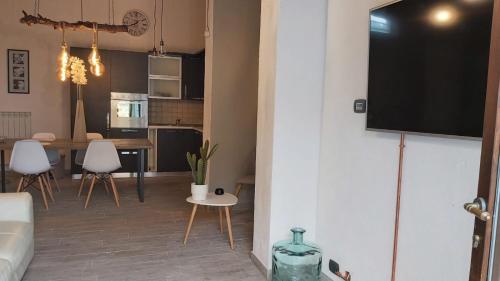 a living room with a table and a tv on a wall at La Limonaia Country House in Monteriggioni