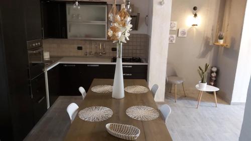 a kitchen with a wooden table with a vase on it at La Limonaia Country House in Monteriggioni