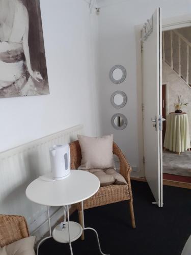 een woonkamer met een witte tafel en een stoel bij Willodean in Walsall