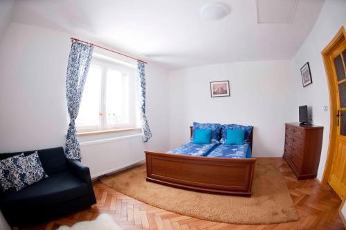 a living room with a bed and a window at Penzion Hájovna in Klíny