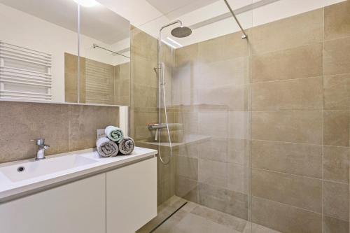 ein Badezimmer mit Dusche und Waschbecken in der Unterkunft Flat Antoine in De Panne