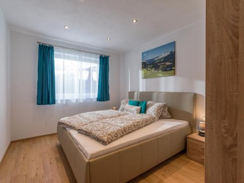 a bedroom with a large bed with blue curtains at Ferienwohnung Treichl in Itter