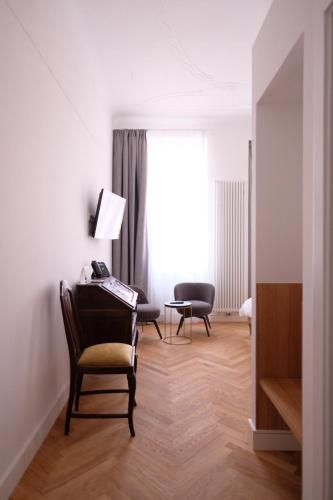 a living room with a chair and a desk at Hotel Lindenufer in Berlin