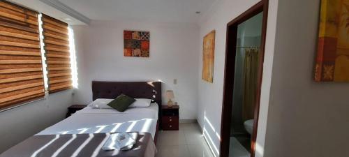 a small bedroom with a bed and a window at Hostal Perla Real Inn in Guayaquil
