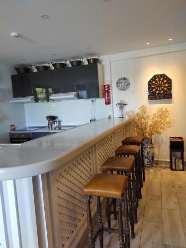 a bar with a row of stools sitting at it at Blife Sun Hostel & Rooms in Faro