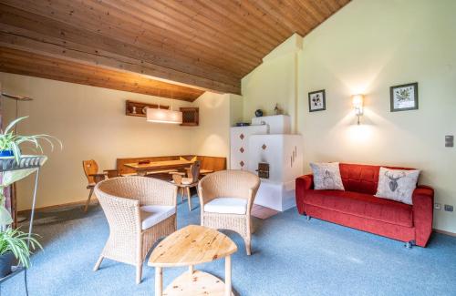 a living room with a red couch and a table at Haus Marianne in Hof bei Salzburg