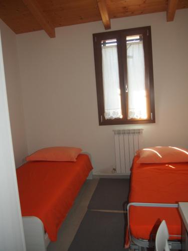 um quarto com 2 camas e uma janela em Agriturismo Ardizio 43 em Pesaro