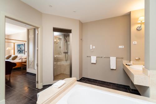 a bathroom with a tub and a sink and a shower at Fairplay Golf & Spa Resort in Benalup Casas Viejas