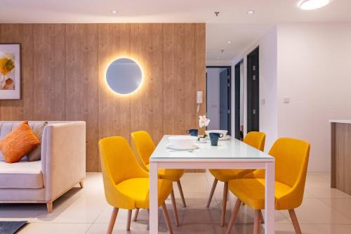 a dining room with a white table and yellow chairs at ❈ Tropicana 218 by ALV Suites ❈ in George Town