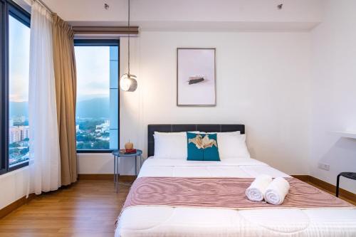 a bedroom with a bed with two towels on it at ❈ Tropicana 218 by ALV Suites ❈ in George Town