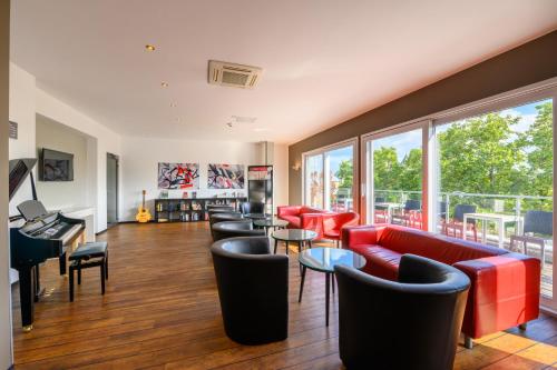 een woonkamer met rode meubels en een balkon bij Art Rock Downtown Hotel in Keulen