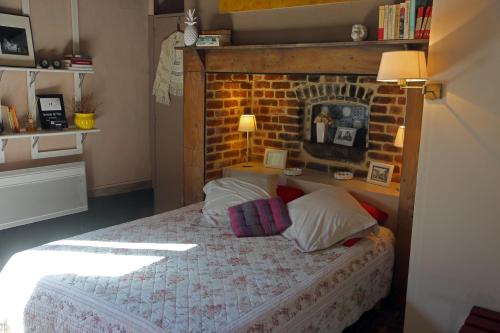 1 dormitorio con cama y pared de ladrillo en Le Collet Vert en Wamin