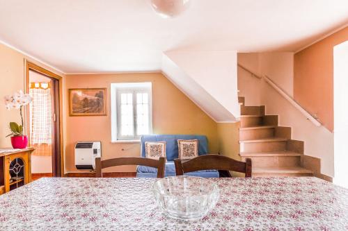 a dining room with a table and chairs and stairs at Casetta Mia in Canistro