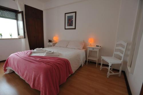a bedroom with a bed and a chair and a window at Lagos Central Apartments Ap 3 in Lagos