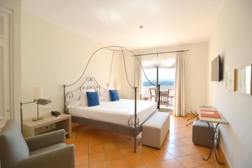 a bedroom with a canopy bed with a view of the ocean at Fairplay Golf & Spa Resort in Benalup Casas Viejas