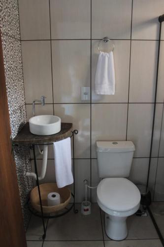 a bathroom with a white toilet and a sink at Casa do Gil in Tiradentes