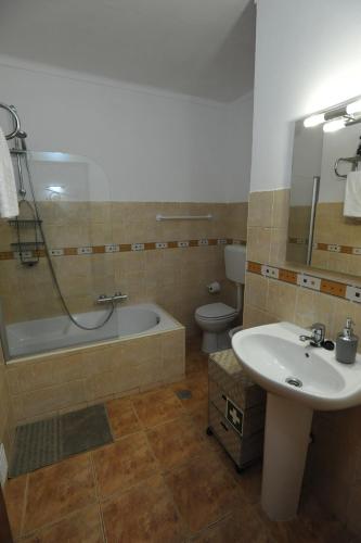 a bathroom with a sink and a tub and a toilet at Lagos Central Apartments Ap 3 in Lagos