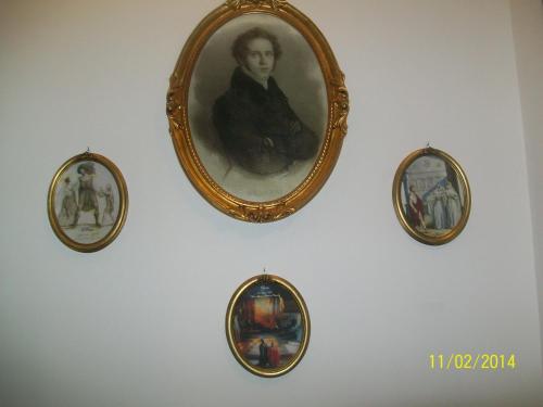 three pictures of a man are hanging on a wall at Rigel Hotel in Catania