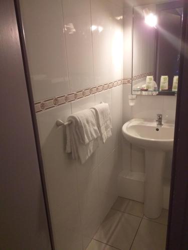 a bathroom with a sink and a shower with towels at Le Mazagan in Port-la-Nouvelle