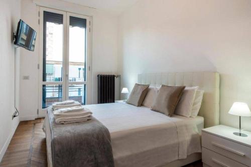 a white bedroom with a large bed and a window at MILAN ROYAL SUITES LUXURY P.ZZA DELLA REPUBBLICA in Milan