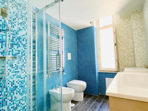 een blauw betegelde badkamer met een toilet en een wastafel bij CASA di Ale & Frank in Salerno
